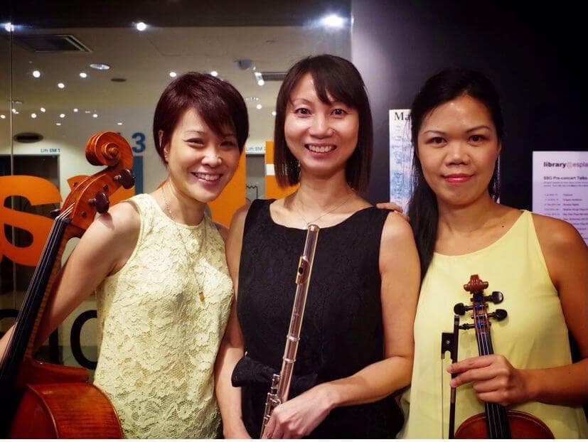 Elaine with two fellow musicians holding their instruments after a performance