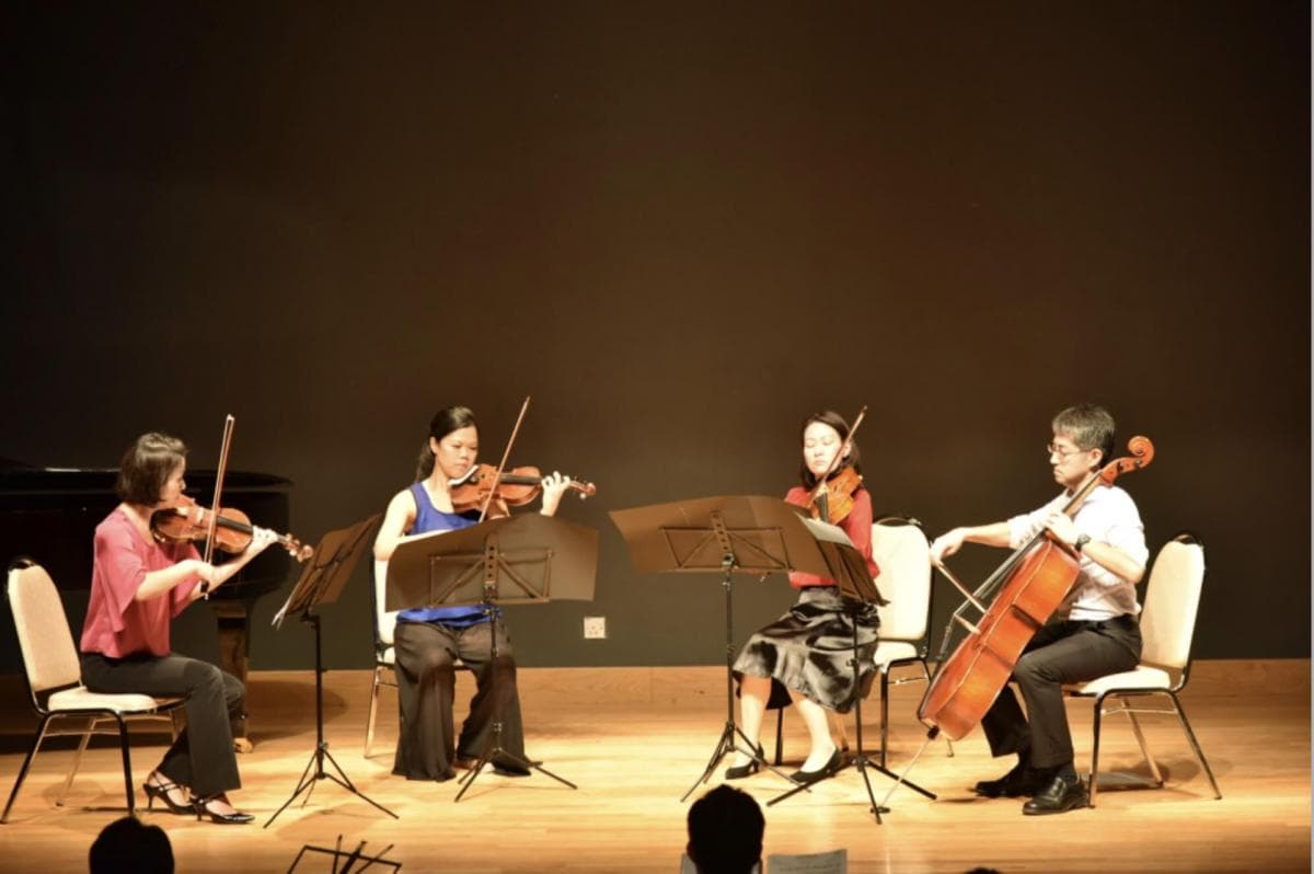 A string quartet performing on a concert hall stage