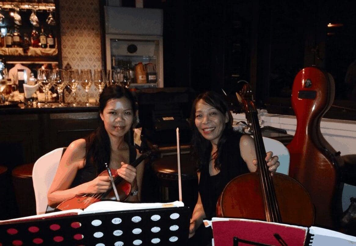 Elaine and a colleague playing at an event beside a double bass