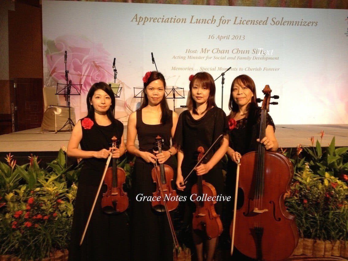 Violinists in black concert dress performing together on stage