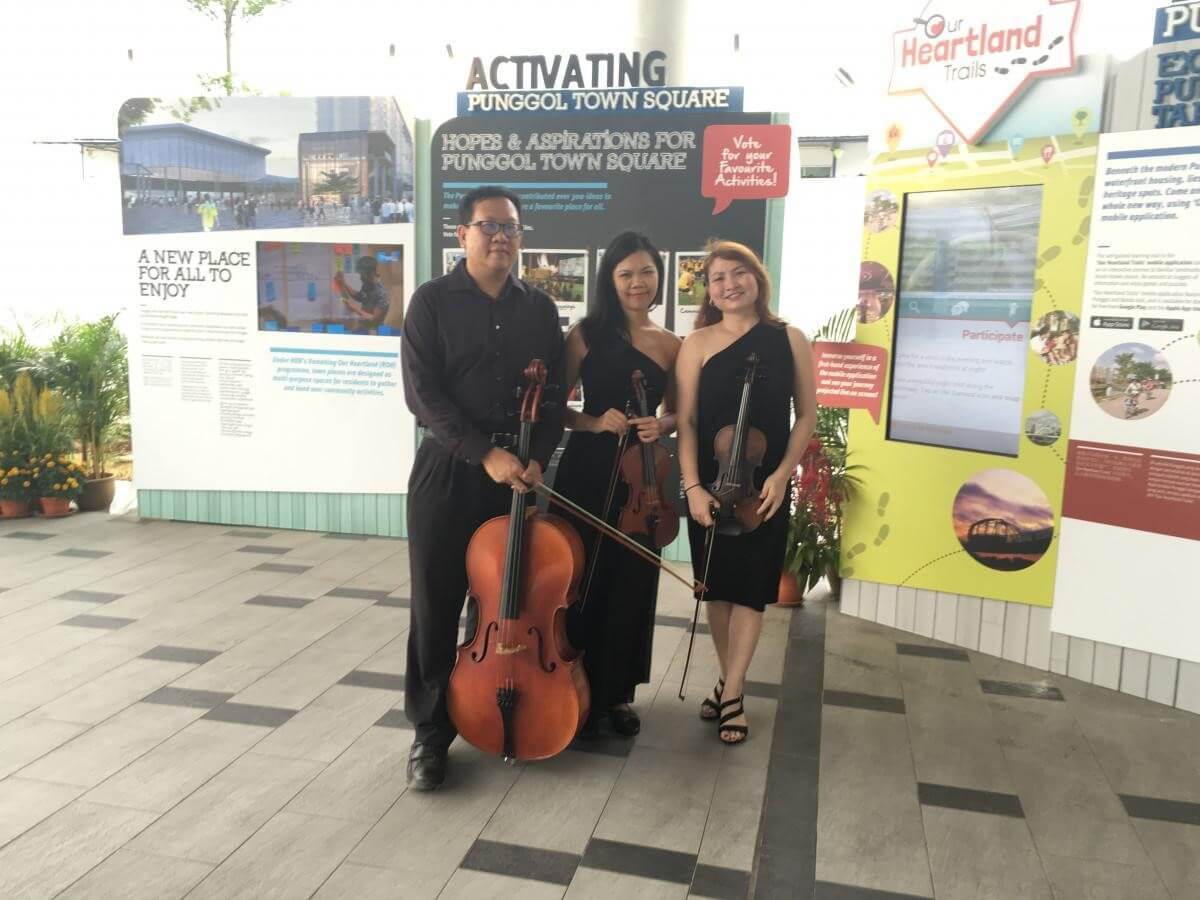 A string quartet with their instruments at an outdoor exhibition