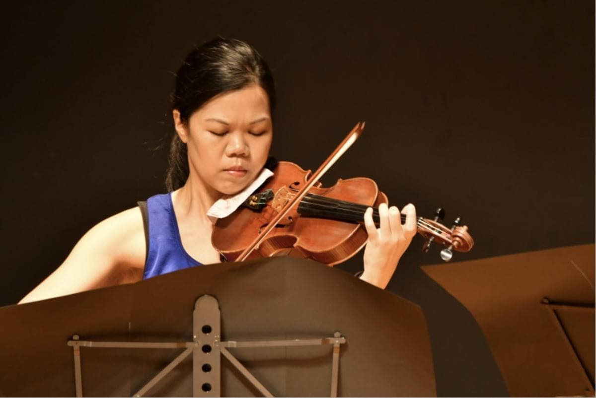 Elaine Khong playing the violin during a recital