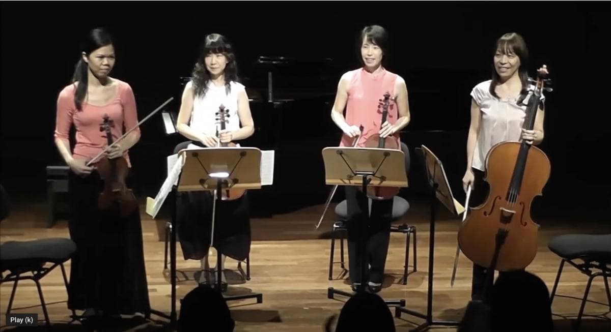 Young violin students performing together at a studio concert